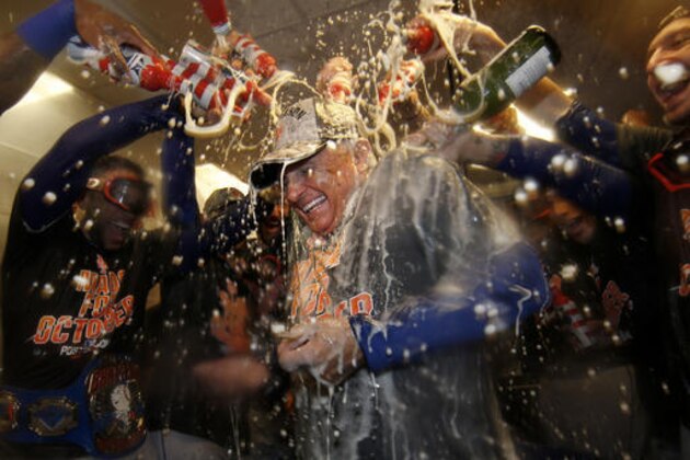 New York Mets manager Terry Colllins is doused with champagne and beer in the clubhouse after the Mets secured a wild card playoff spot by defeating the Philadelphia Phillies 5-3 in a baseball game, Saturday, Oct. 1, 2016, in Philadelphia. (AP Photo/Laurence Kesterson)
