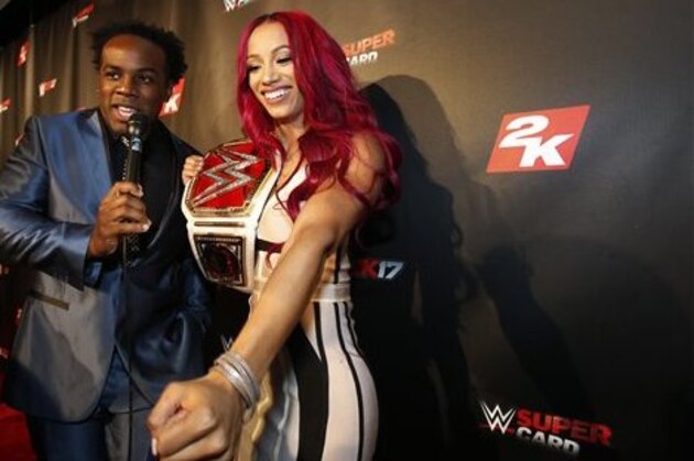 IMAGE DISTRIBUTED FOR 2K - WWE Women's Champion Sasha Banks speaks with WWE Superstar Xavier Woods, left, on the red carpet at the WWE 2K17 SummerSlam Kickoff Event in New York, on Friday, Aug. 19, 2016. (Adam Hunger/AP Images for 2K)