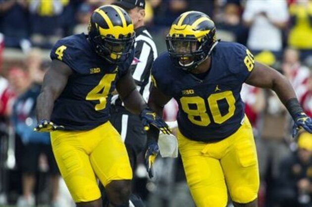 Michigan running back De'Veon Smith (4) celebrates with fullback Khalid Hill (80) after Hill scores a touchdown in the second quarter of an NCAA college football game against Wisconsin at Michigan Stadium in Ann Arbor, Mich., Saturday, Oct. 1, 2016. (AP Photo/Tony Ding)