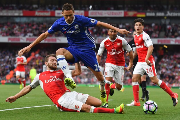 Arsenal's German defender Shkodran Mustafi (L) slides in to tackle Chelsea's Serbian midfielder Nemanja Matic (2L) during the English Premier League football match between Arsenal and Chelsea at the Emirates Stadium in London on September 24, 2016.  / AFP / Ben STANSALL / RESTRICTED TO EDITORIAL USE. No use with unauthorized audio, video, data, fixture lists, club/league logos or 'live' services. Online in-match use limited to 75 images, no video emulation. No use in betting, games or single club/league/player publications.  /         (Photo credit should read BEN STANSALL/AFP/Getty Images)
