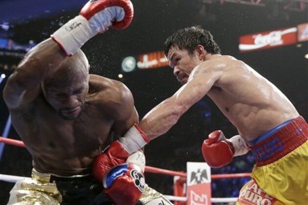 Manny Pacquiao, from the Philippines, right, punches Floyd Mayweather Jr., during their welterweight title fight on Saturday, May 2, 2015 in Las Vegas. (AP Photo/Isaac Brekken)