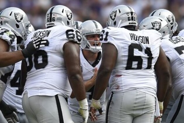 Oakland Raiders quarterback Derek Carr, center, huddles with teammates in the second half of an NFL football game against the Baltimore Ravens, Sunday, Oct. 2, 2016, in Baltimore. (AP Photo/Gail Burton)