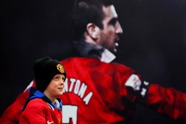 MANCHESTER, ENGLAND - APRIL 04:  A fan poses next to a poster of former Manchester United player Eric Cantona before the Barclays Premier League match between Manchester United and Aston Villa at Old Trafford on April 4, 2015 in Manchester, England.  (Photo by Jan Kruger/Getty Images)