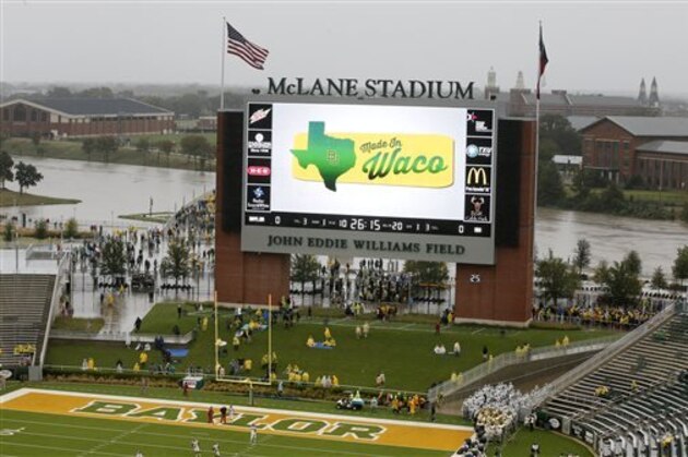 The swollen Brazos river is seen at rear behind the end zone video screen at McLane Stadium before an NCAA college football game between Iowa State and Baylor Saturday, Oct. 24, 2015, in Waco, Texas. The region has endured double-digit inches of rain with more in the forecast throughout the weekend.  (AP Photo/Tony Gutierrez)