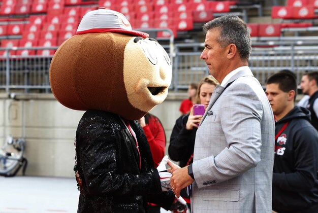 Oct 1, 2016; Columbus, OH, USA; Ohio State Buckeyes head coach Urban Meyer shakes hands with mascot Brutus Buckeye before the game against the Rutgers Scarlet Knights at Ohio Stadium. Mandatory Credit: Greg Bartram-USA TODAY Sports