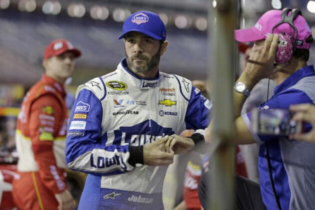 Jimmie Johnson waits by his car before qualifying for Saturday's NASCAR Sprint Cup series auto race at Charlotte Motor Speedway in Charlotte, N.C., Thursday, Oct. 6, 2016. (AP Photo/Chuck Burton)