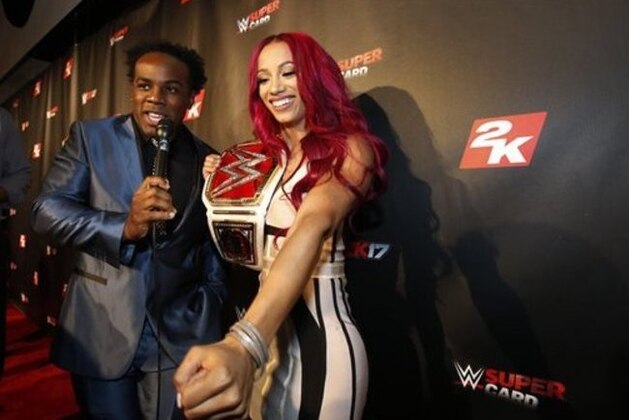 IMAGE DISTRIBUTED FOR 2K - WWE Women's Champion Sasha Banks speaks with WWE Superstar Xavier Woods, left, on the red carpet at the WWE 2K17 SummerSlam Kickoff Event in New York, on Friday, Aug. 19, 2016. (Adam Hunger/AP Images for 2K)
