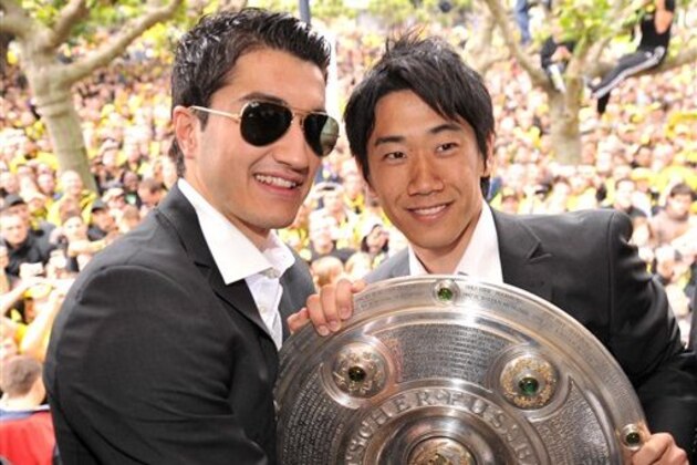 Nuri Sahin, left and Shinji Kagawa  of Borussia Dortmund soccer team celebrate their soccer championship with the trophy  during a parade in Dortmund, Germany Sunday May 15, 2011. (AP Photo/Torsten Silz,Pool)
