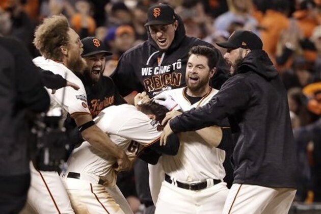 San Francisco Giants' Joe Panik, center bottom, is congratulated by teammates after hitting a double to score Brandon Crawford during the thirteenth inning of Game 3 of baseball's National League Division Series against the Chicago Cubs in San Francisco, Monday, Oct. 10, 2016. The  Giants won 6-5. (AP Photo/Marcio Jose Sanchez)