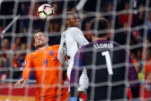 Netherlands' Vincent Janssen, left, heads the ball with France's Djibril Sidibe, center, while France's goalkeeper Hugo Lloris looks on  during the World Cup Group A qualifying soccer match in the ArenA stadium in Amsterdam, Netherlands, Monday, Oct. 10, 2016. France defeated Netherlands 1-0. (AP Photo/Peter Dejong)