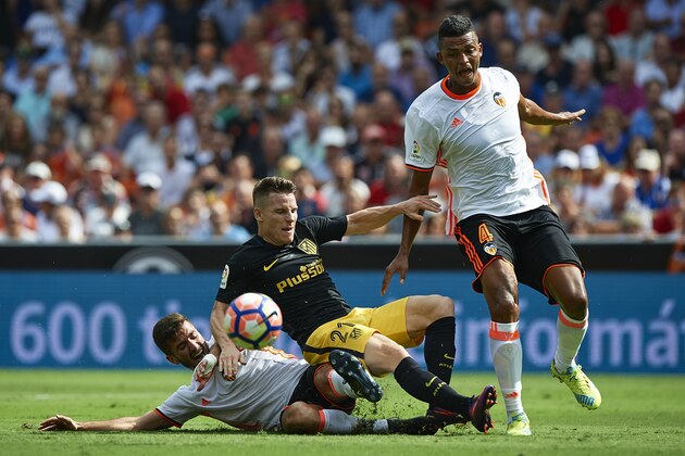 VALENCIA, SPAIN - OCTOBER 02:  Kevin Gameiro of Atletico de Madrid is tackled by Jose Luis Gaya and Aderlan Santos (R) of Valencia during the La Liga match between Valencia CF and Atletico de Madrid at Mestalla Stadium on October 02, 2016 in Valencia, Spain.  (Photo by Manuel Queimadelos Alonso/Getty Images)