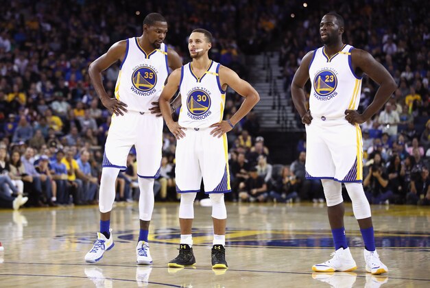 OAKLAND, CA - OCTOBER 04:  Kevin Durant #35, Stephen Curry #30, and Draymond Green #23 of the Golden State Warriors stand on the court during their game against the Los Angeles Clippers during their preseason game at ORACLE Arena on October 4, 2016 in Oakland, California.  NOTE TO USER: User expressly acknowledges and agrees that, by downloading and or using this photograph, User is consenting to the terms and conditions of the Getty Images License Agreement.  (Photo by Ezra Shaw/Getty Images)