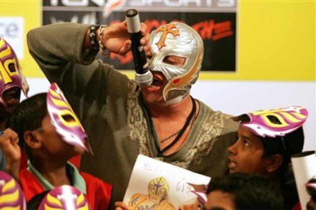 FILE - In this March 13, 2007 file photo, World Wrestling Entertainment star Rey Mysterio interacts with school children in Mumbai, India. Months after the in-ring death of Mexican star Perro Aguayo, Mysterio has not only returned to the ring, he will headline a pay-per-view card Sunday, Aug. 9, 2015, for top Mexican promotion AAA. An undersized underdog, Mysterio hoped he could honor his friend by pushing forward in the ring.(AP Photo/Rajesh Nirgude)