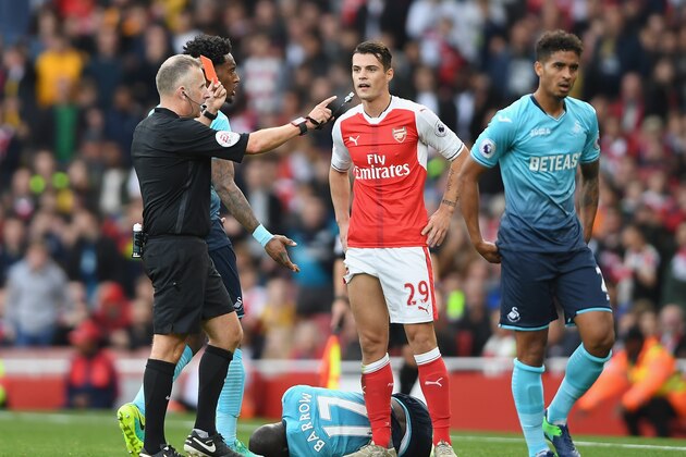 LONDON, ENGLAND - OCTOBER 15: Referee Jonanthan Moss (L) shows Granit Xhaka of Arsenal (C) a red card for a foul on Modou Barrow of Swansea City during the Premier League match between Arsenal and Swansea City at Emirates Stadium on October 15, 2016 in London, England.  (Photo by Mike Hewitt/Getty Images)