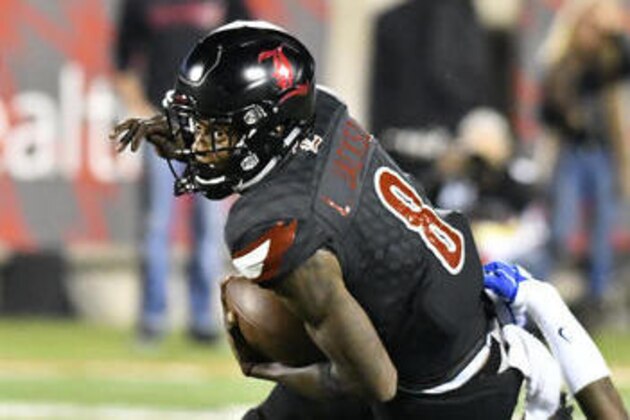 Louisville quarterback Lamar Jackson (8) fights to get out of the grasp of Duke defensive end Marquies Price (91) during the second half of an NCAA college football game, Friday, Oct. 14, 2016, in Louisville, Ky. (AP Photo/Timothy D. Easley)