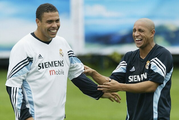 KUNMING, CHINA - JULY 28:  Ronaldo and Roberto Carlos of Real Madrid share a joke during a training session on July 28, 2003 at the Hongta Sports Centre in Kunming, China.(Photo by Alex Livesey/Getty Images)