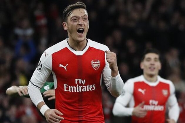 Arsenal's Mesut Ozil, left, celebrates after scoring his side's fifth goal  during the Champions League Group A soccer match between Arsenal and Ludogorets Razgrad at Emirates stadium in London Wednesday, Oct. 19, 2016. (AP Photo/Kirsty Wigglesworth)