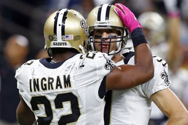 New Orleans Saints running back Mark Ingram (22) comforts quarterback Drew Brees (9) after he was hit in the face by Carolina Panthers defensive tackle Kawann Short in the second half of an NFL football game in New Orleans, Sunday, Oct. 16, 2016. Short was penalized for a personal foul, but Brees completed a touchdown pass on the play. (AP Photo/Butch Dill)