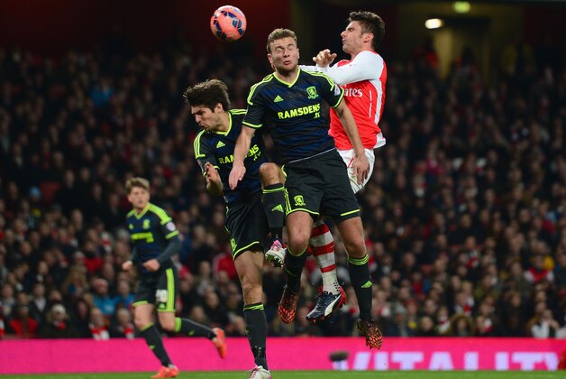 LONDON, ENGLAND - FEBRUARY 15:  Olivier Giroud of Arsenal competes for the ball with Ben Gibson of Middlesbrough (C) during the FA Cup fifth round match between Arsenal and Middlesbrough at Emirates Stadium on February 15, 2015 in London, England.  (Photo by Jamie McDonald/Getty Images)
