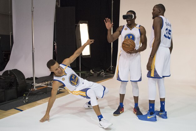 September 26, 2016; Oakland, CA, USA; Golden State Warriors guard Stephen Curry (30) and forward Kevin Durant (35) joke with forward Andre Iguodala (9) while Iguodala wore a virtual reality headset during media day at the Warriors Practice Facility. Mandatory Credit: Kyle Terada-USA TODAY Sports