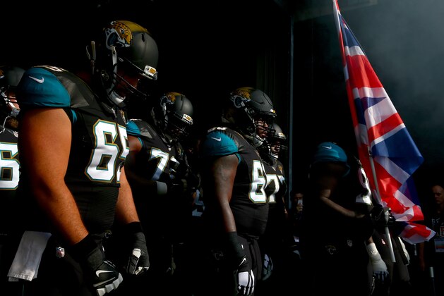 LONDON, ENGLAND - OCTOBER 02:  Sen'Derrick Marks #99 of the Jacksonville Jaguars holds a Union Jack flag as he prepares to run out with Brandon Linder #65 and Kelvin Beachum #68 of the Jacksonville Jaguars for the NFL game between Indianapolis Colts and Jacksonville Jaguars at Wembley Stadium on October 2, 2016 in London, England.  (Photo by Dan Istitene/Getty Images)