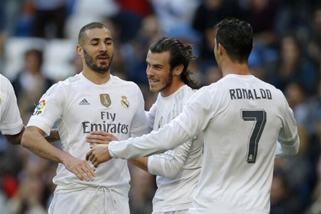 Real Madrid's Karim Benzema, left, celebrates with teammates Cristiano Ronaldo, right, and Gareth Bale after scoring their side's third goal against Getafe during the Spanish La Liga soccer match between Real Madrid and Getafe at the Santiago Bernabeu stadium in Madrid, Saturday, Dec. 5, 2015. Benzema scored twice and Ronaldo and Bale scored once each in Real Madrid's 4-1 victory. (AP Photo/Francisco Seco)