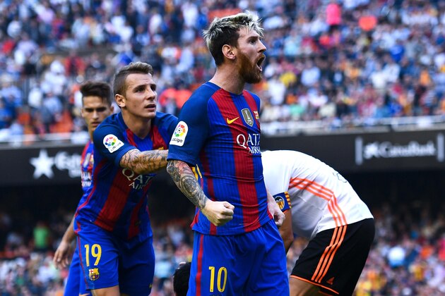 VALENCIA, SPAIN - OCTOBER 22:  Lionel Messi of FC Barcelona celebrates with his team mates as Neymar Jr. and Luis Suarez reacts on the pitch after being hit by objects thrown from the seats after scoring his team's third from the penalty spot during the La Liga match between Valencia CF and FC Barcelona at Mestalla stadium on October 22, 2016 in Valencia, Spain.  (Photo by David Ramos/Getty Images)