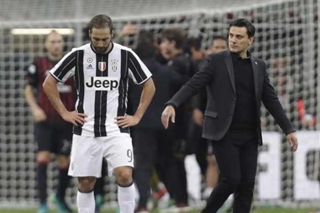 AC Milan coach Vincenzo Montella, right comforts Juventus' Gonzalo Higuain after Milan won 1 - 0 during a Serie A soccer match between AC Milan and Juventus, at the San Siro stadium in Milan, Italy, Saturday, Oct. 22, 2016. (AP Photo/Luca Bruno)