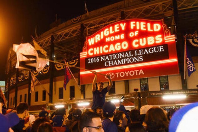 Chicago Cubs fans celebrate outside Wrigley Field after the Cubs defeated the Los Angeles Dodgers 5-0 in Game 6 of baseball's National League Championship Series, Saturday, Oct. 22, 2016, in Chicago. The Cubs advanced to the World Series. (AP Photo/Matt Marton)