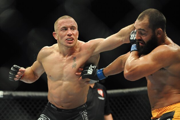 Nov 16, 2013; Las Vegas, NV, USA; Georges St-Pierre (red gloves) fights against Johny Hendricks (blue gloves) in their welterweight championship bout during UFC 167 at MGM Grand Garden Arena. Mandatory Credit: Stephen R. Sylvanie-USA TODAY Sports