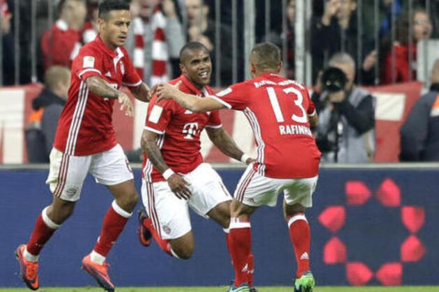 Bayern's Douglas Costa, center, celebrates with team mates Rafinha, right, and Thiago after scoring his side's second goal during the German Bundesliga soccer match between FC Bayern Munich and Borussia Moenchengladbach at the Allianz Arena stadium in Munich, Germany, Saturday, Oct. 22, 2016. (AP Photo/Matthias Schrader)