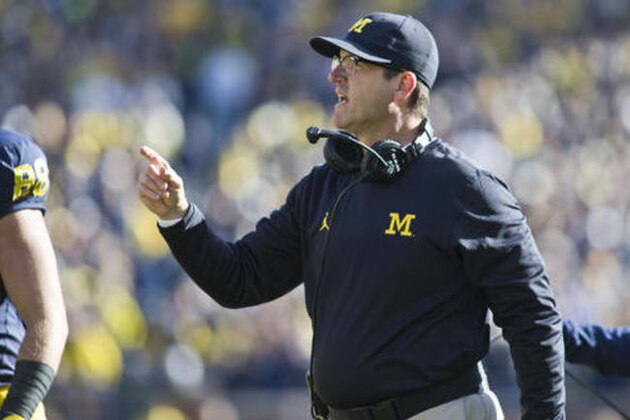 Michigan head coach Jim Harbaugh gives advice to his offensive players coming off the field after a touchdown in the first quarter of an NCAA college football game against Illinois at Michigan Stadium in Ann Arbor, Mich., Saturday, Oct. 22, 2016. Michigan won 41-8. (AP Photo/Tony Ding)