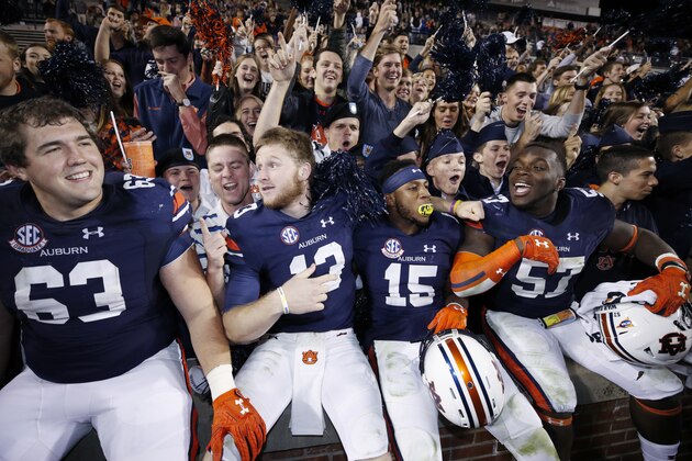 AUBURN, AL - OCTOBER 22: Alex Kozan #63, Sean White #13, Joshua Holsey #15 and Deshaun Davis #57 of the Auburn Tigers celebrate with fans after the game against the Arkansas Razorbacks at Jordan-Hare Stadium on October 22, 2016 in Auburn, Alabama. Auburn defeated Arkansas 56-3. (Photo by Joe Robbins/Getty Images)