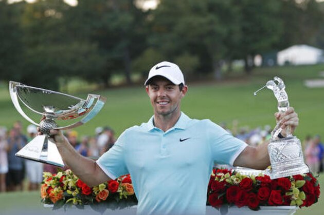 Rory McIlroy poses with the trophies after winning the Tour Championship golf tournament and FedEX Cup at East Lake Golf Club, Sunday, Sept. 25, 2016, in Atlanta. (AP Photo/John Bazemore)
