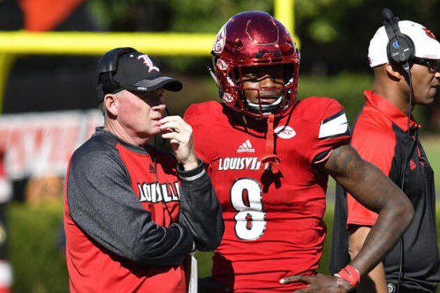Louisville head coach Bobby Petrino talks with Lamar Jackson (8) during a time out in their NCAA college football game against North Carolina State, Saturday, Oct. 22, 2016, in Louisville, Ky. Louisville won 54-13. (AP Photo/Timothy D. Easley)
