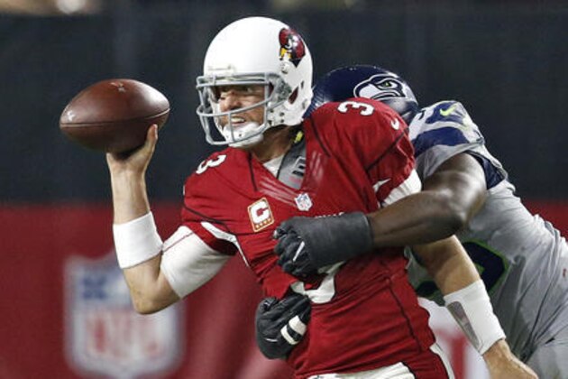 Arizona Cardinals quarterback Carson Palmer (3) his hit as he makes the throw by Seattle Seahawks defensive end Cliff Avril during the first half of a football game, Sunday, Oct. 23, 2016, in Glendale, Ariz. (AP Photo/Ross D. Franklin)