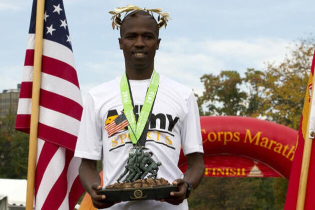 Samuel Kosgei, from Junction City, Kan., holds his trophy after winning the 41st Marine Corps Marathon, Sunday, Oct. 30, 2016 in Arlington, Va. The race includes runners from 55 nations and each branch of the U.S. armed forces. ( AP Photo/Jose Luis Magana)