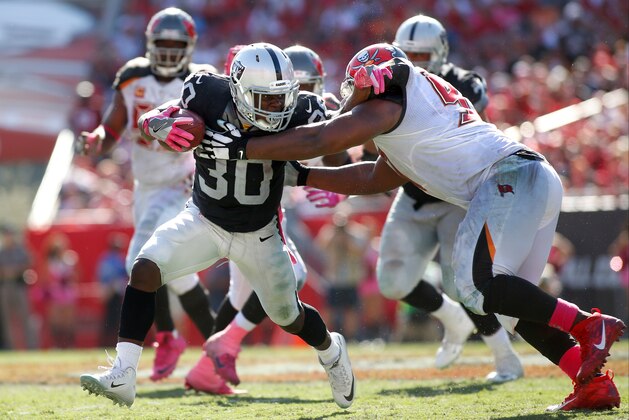 TAMPA, FL - OCTOBER 30:  Running back Jalen  Richards #30 of the Oakland Raiders fends off defensive tackle Akeem Spence #97 of the Tampa Bay Buccaneers during a carry in the fourth quarter of an NFL game on October 30, 2016 at Raymond James Stadium in Tampa, Florida. (Photo by Brian Blanco/Getty Images)
