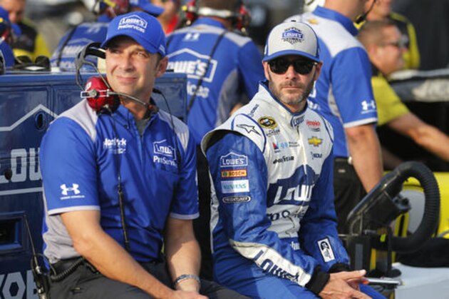 Jimmie Johnson, right, waits along with crew chief Chad Knaus as they wait for qualifying for the NASCAR Sprint Cup auto race at Richmond International Raceway in Richmond, Va., Friday, Sept. 9, 2016. (AP Photo/Steve Helber)
