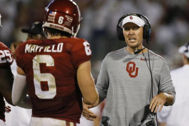 FILE - In this Sept. 17, 2016, file photo, Oklahoma offensive coordinator Lincoln Riley, right, talks to quarterback Baker Mayfield (6) during an NCAA college football game against Ohio State in Norman, Okla. Riley has taken some of the air out of the Air Raid, and the results have been spectacular.. Once Riley put a little more ground and pound into Oklahoma’s high-octane attack, everything clicked. He ran into problems this year against Houston and Ohio State, but again, bounced back with the ground game. (AP Photo/Sue Ogrocki, File)