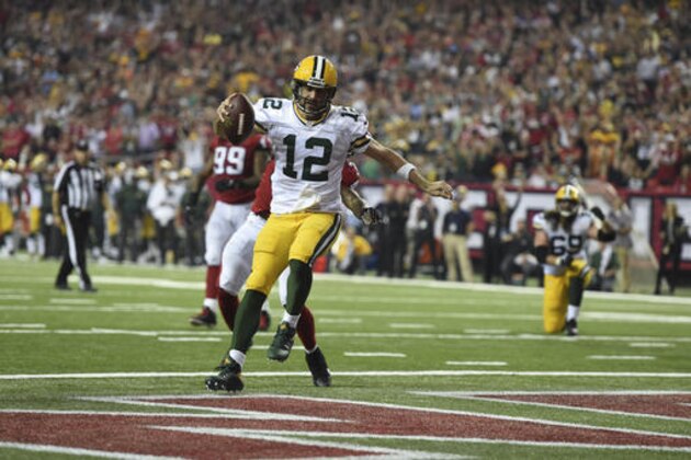 Green Bay Packers quarterback Aaron Rodgers (12) runs onto the end zone for a point after play against Atlanta Falcons free safety Ricardo Allen (37) during the second of an NFL football game, Sunday, Oct. 30, 2016, in Atlanta. (AP Photo/Rainier Ehrhardt)