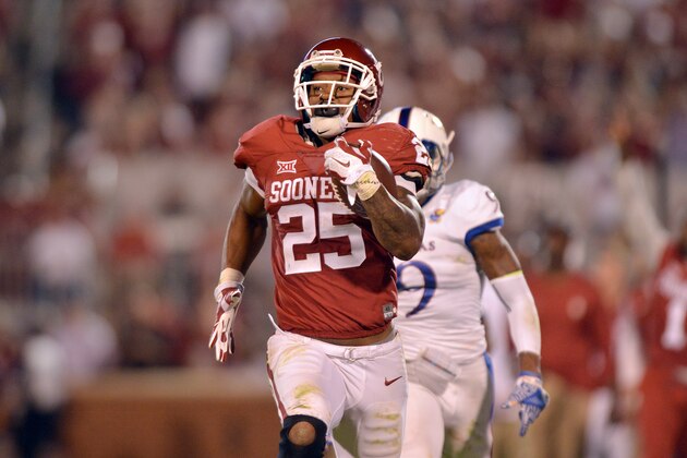 NORMAN, OK - OCTOBER 29: Running back Joe Mixon #25 of the Oklahoma Sooners runs past safety Fish Smithson #9 of the Kansas Jayhawks during second half play of their win on October 29, 2016 at Gaylord Family Oklahoma Memorial Stadium in Norman, Oklahoma. (Photo by Jackson Laizure/Getty Images)