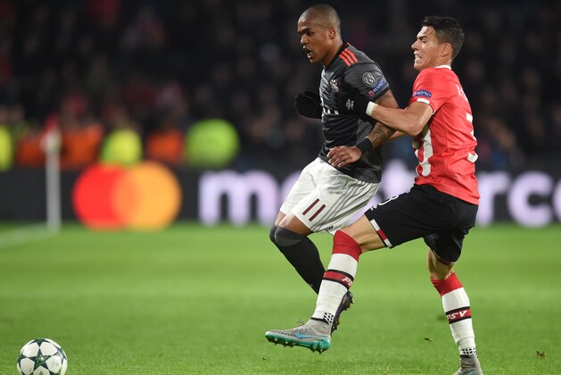 Bayern Munich's Brazilian midfielder Douglas Costa (L) challenges PSV Eindhoven's Mexican defender Hector Moreno during the UEFA Champions League group D football match between PSV Eindhoven and Bayern Munich at the Philips Stadium in Eindhoven on November 1, 2016. / AFP / CHRISTOF STACHE        (Photo credit should read CHRISTOF STACHE/AFP/Getty Images)