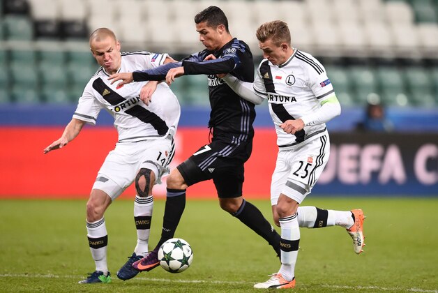 Real Madrid's Portuguese forward Cristiano Ronaldo (C) is challanged by Legia Warsaw's Czech defender Adam Hlousek (L) and Legia Warsaw's defender Jakub Rzezniczak vie for the ball during the UEFA Champions League group F football match Legia Warsaw vs Real Madrid CF in Warsaw, Poland on November 2, 2016. / AFP / ODD ANDERSEN        (Photo credit should read ODD ANDERSEN/AFP/Getty Images)