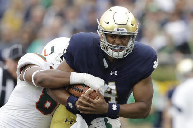 Notre Dame quarterback DeShone Kizer (14) is tackled by Miami 's RJ McIntosh during the first half of an NCAA college football game Saturday, Oct. 29, 2016, in South Bend, Ind. (AP Photo/Darron Cummings)