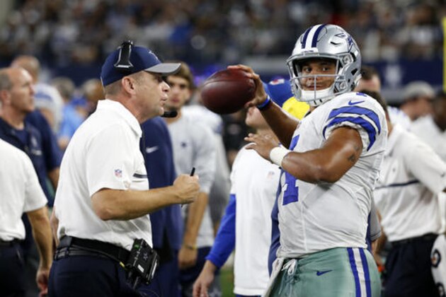 Dallas Cowboys offensive coordinator Scott Linehan, left, talks with quarterback Dak Prescott (4) as he throws a warm up pass during an NFL football game against the Philadelphia Eagles on Sunday, Oct. 30, 2016, in Arlington, Texas. (AP Photo/Michael Ainsworth)