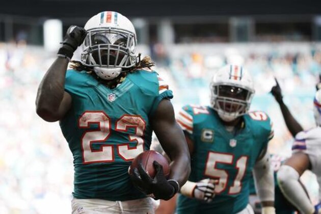 Miami Dolphins running back Jay Ajayi (23) celebrates a touchdown during the second half of an NFL football game against the Buffalo Bills, Sunday, Oct. 23, 2016, in Miami Gardens, Fla. To the right is Miami Dolphins center Mike Pouncey (51). (AP Photo/Wilfredo Lee)