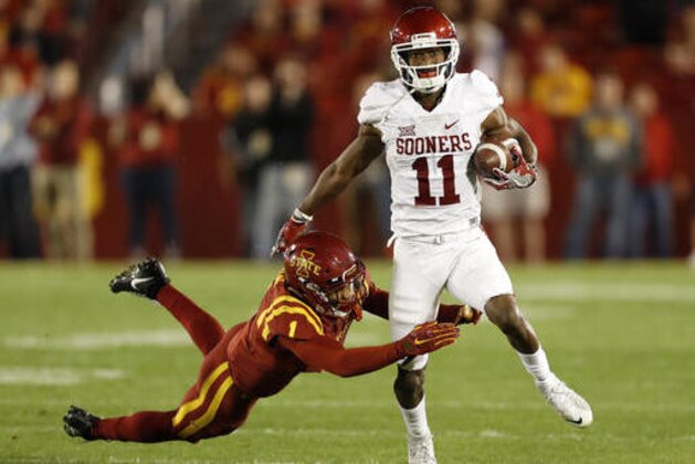 Oklahoma wide receiver Dede Westbrook (11) breaks a tackle by Iowa State defensive back D'Andre Payne, left, during the first half of an NCAA college football game, Thursday, Nov. 3, 2016, in Ames, Iowa. (AP Photo/Charlie Neibergall)