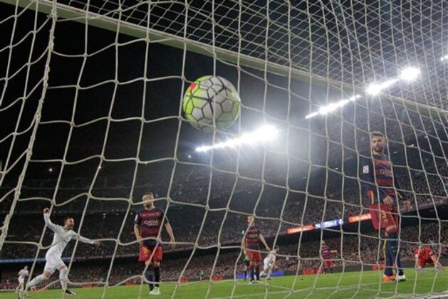 Barcelona goalkeeper Claudio Bravo, right, and Gerard Pique, 2nd right, watch the ball hit the net after Real Madrid's Cristiano Ronaldo scored the winning goal during a Spanish La Liga soccer match between Barcelona and Real Madrid, dubbed 'el clasico', at the Camp Nou stadium in Barcelona, Spain, Saturday, April 2, 2016. Real Madrid won  2-1. (AP Photo/Manu Fernandez)