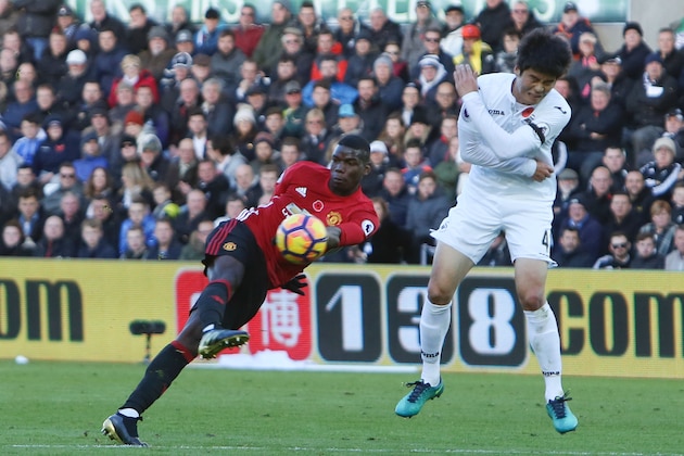 Manchester United's French midfielder Paul Pogba (L) shoots to score his team's first goal during the English Premier League football match between Swansea City and Manchester United at The Liberty Stadium in Swansea, south Wales on November 6, 2016. / AFP / Geoff CADDICK / RESTRICTED TO EDITORIAL USE. No use with unauthorized audio, video, data, fixture lists, club/league logos or 'live' services. Online in-match use limited to 75 images, no video emulation. No use in betting, games or single club/league/player publications.  /         (Photo credit should read GEOFF CADDICK/AFP/Getty Images)